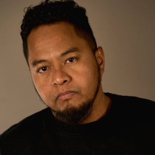 Faizal Abdullah wearing a black t-shirt and looking directly at the camera.
